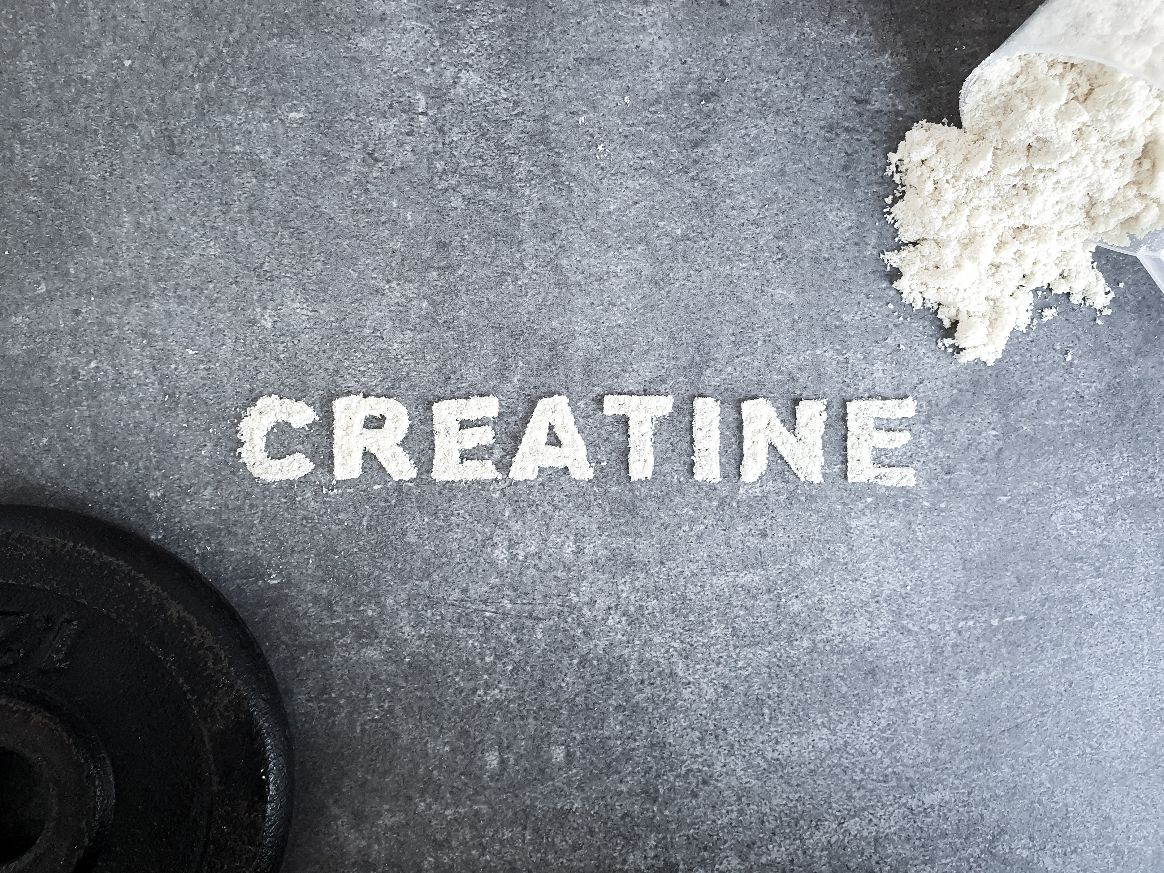 Creatine powder poured into the design of letters spelling creaitne