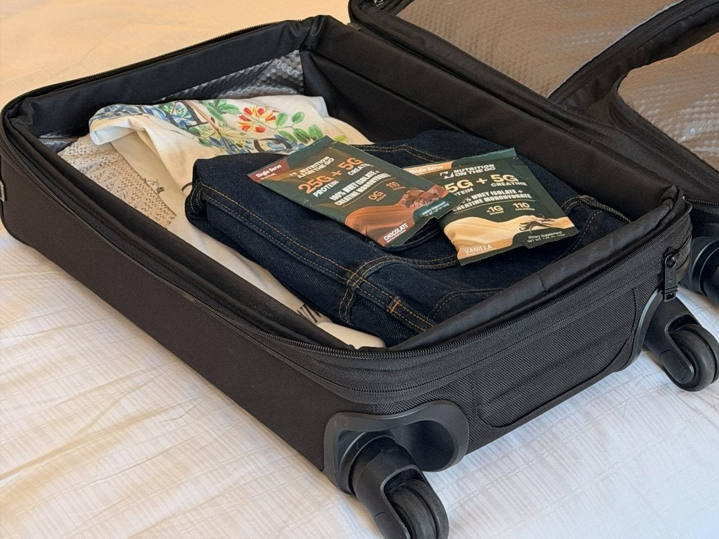 Two Nutrition On The Go packets packed in an open carry-on suitcase