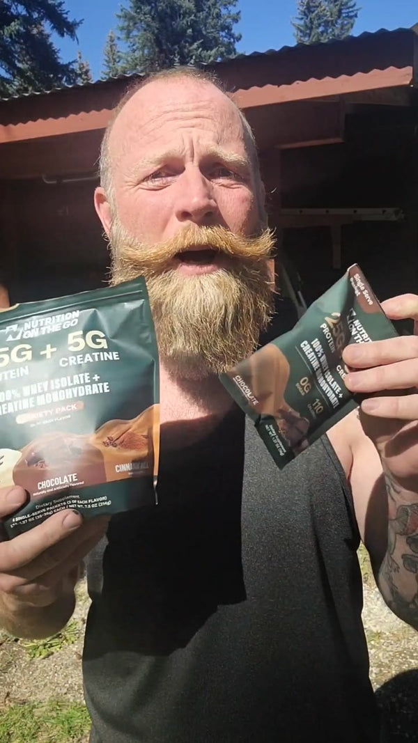 Dan J. holding a Nutrition On The Go variety pack and a chocolate packet