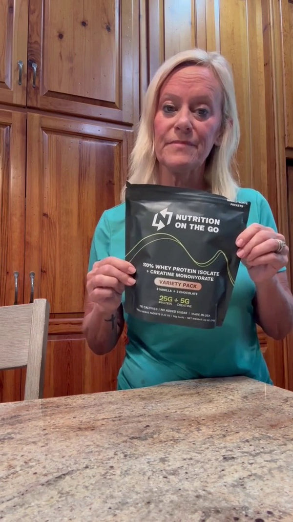 Kathy G. holding a Nutrition On The Go variety bag in her kitchen