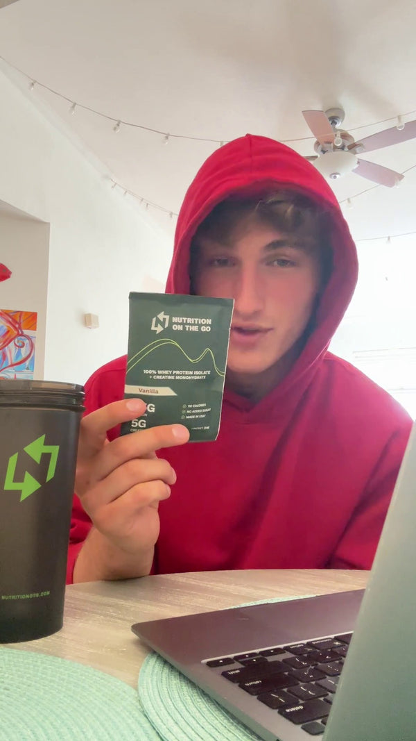 Ty B. holding a Nutrition On The Go packet at his desk
